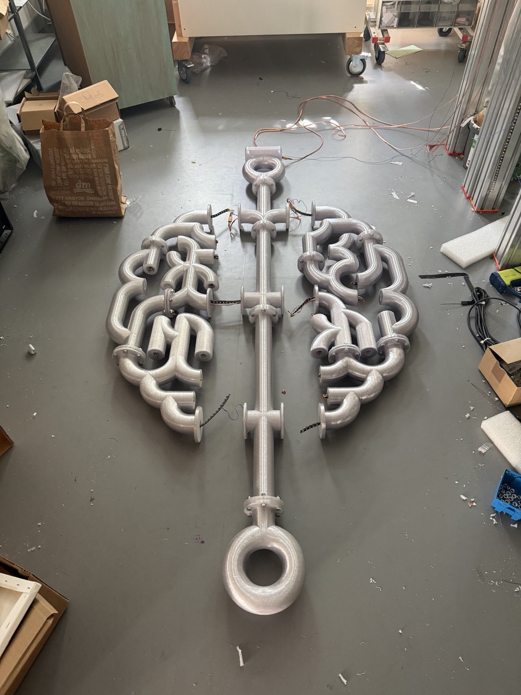 Die Skulptur unbeleuchtet am Werkstattboden, die gedruckten Röhren in hellem Kunststoff